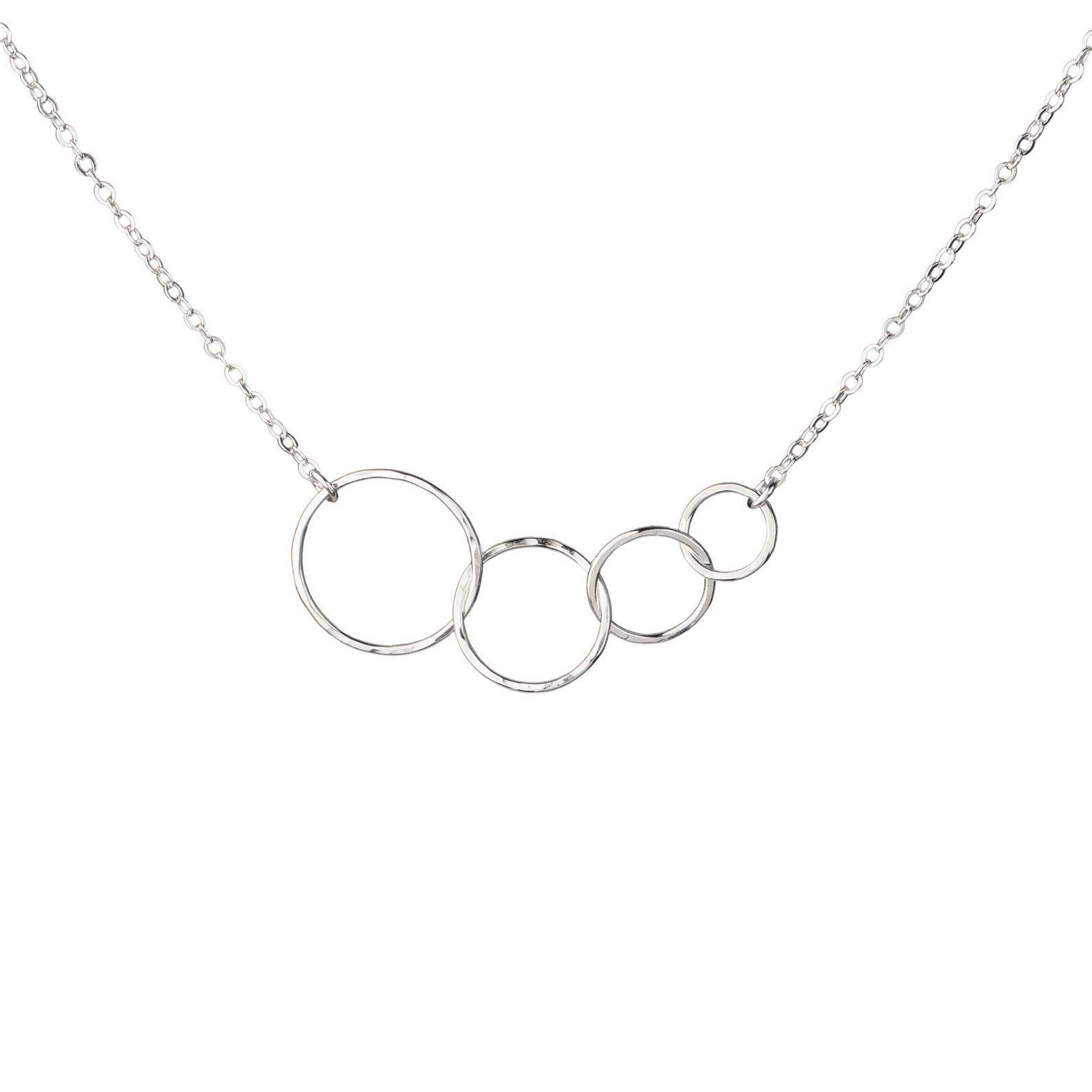 A silver necklace featuring four interlocking, open circular rings of varying sizes on a delicate silver cable chain, shown against a plain white background.