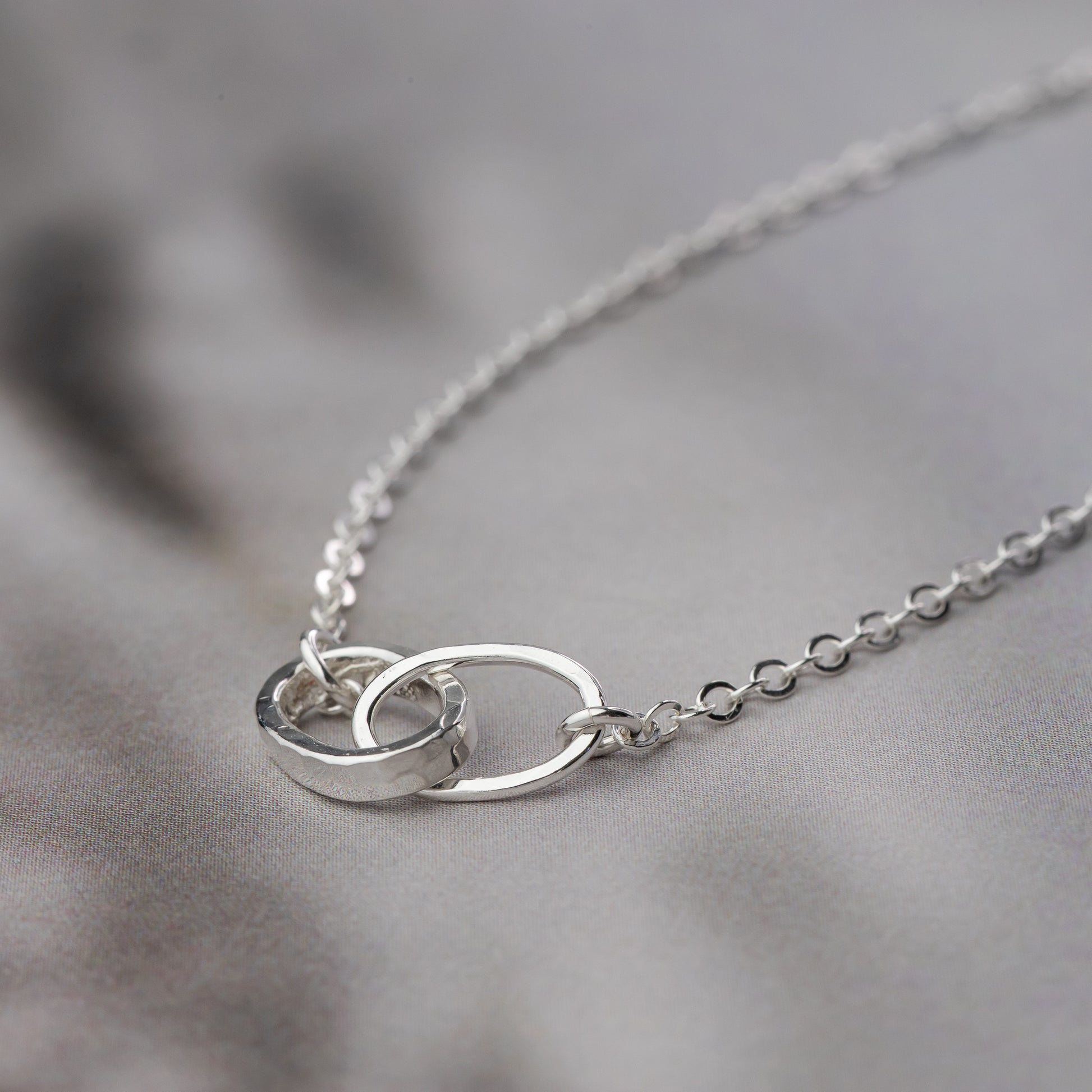 handmade sterling silver necklace with interlocking links on a soft gray background