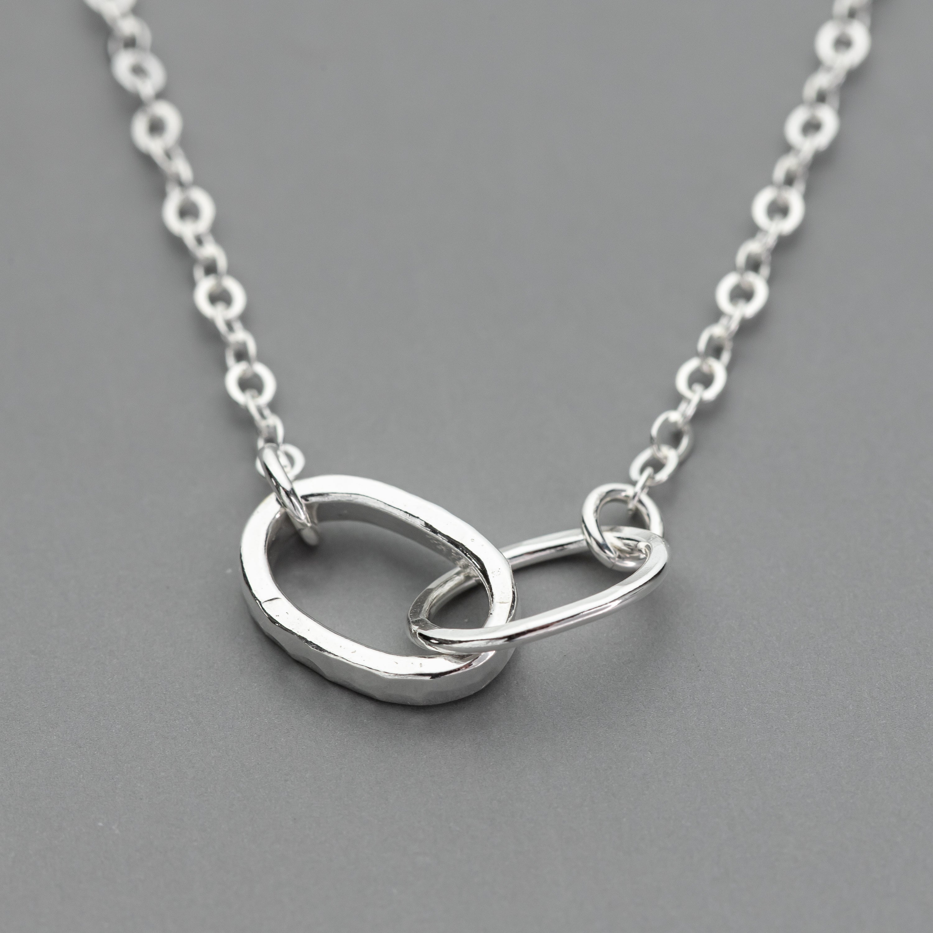 sterling Silver necklace with interlocking rings on a gray background