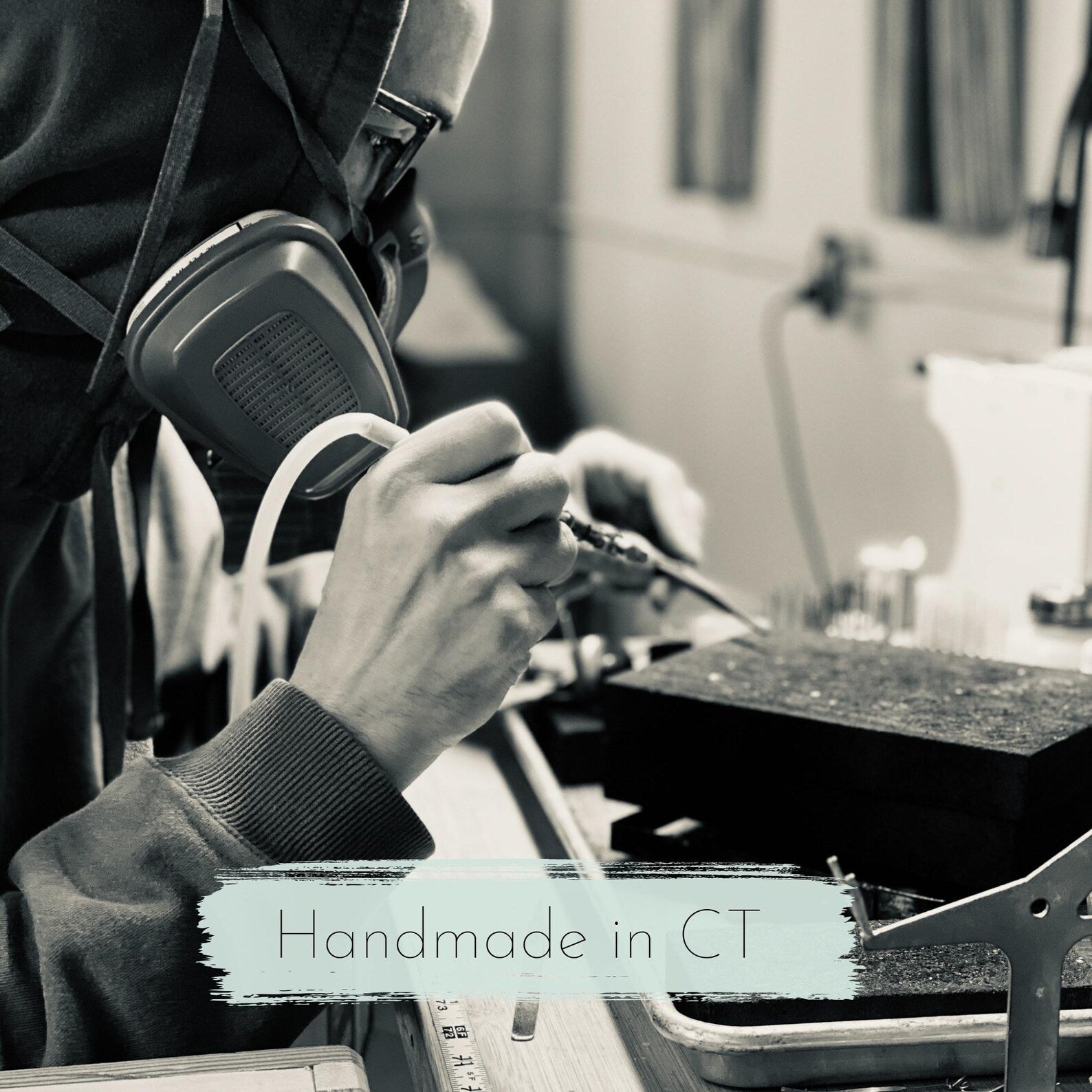 Person working with tools in a workshop, wearing protective gear, with 'Handmade in CT' text overlay.