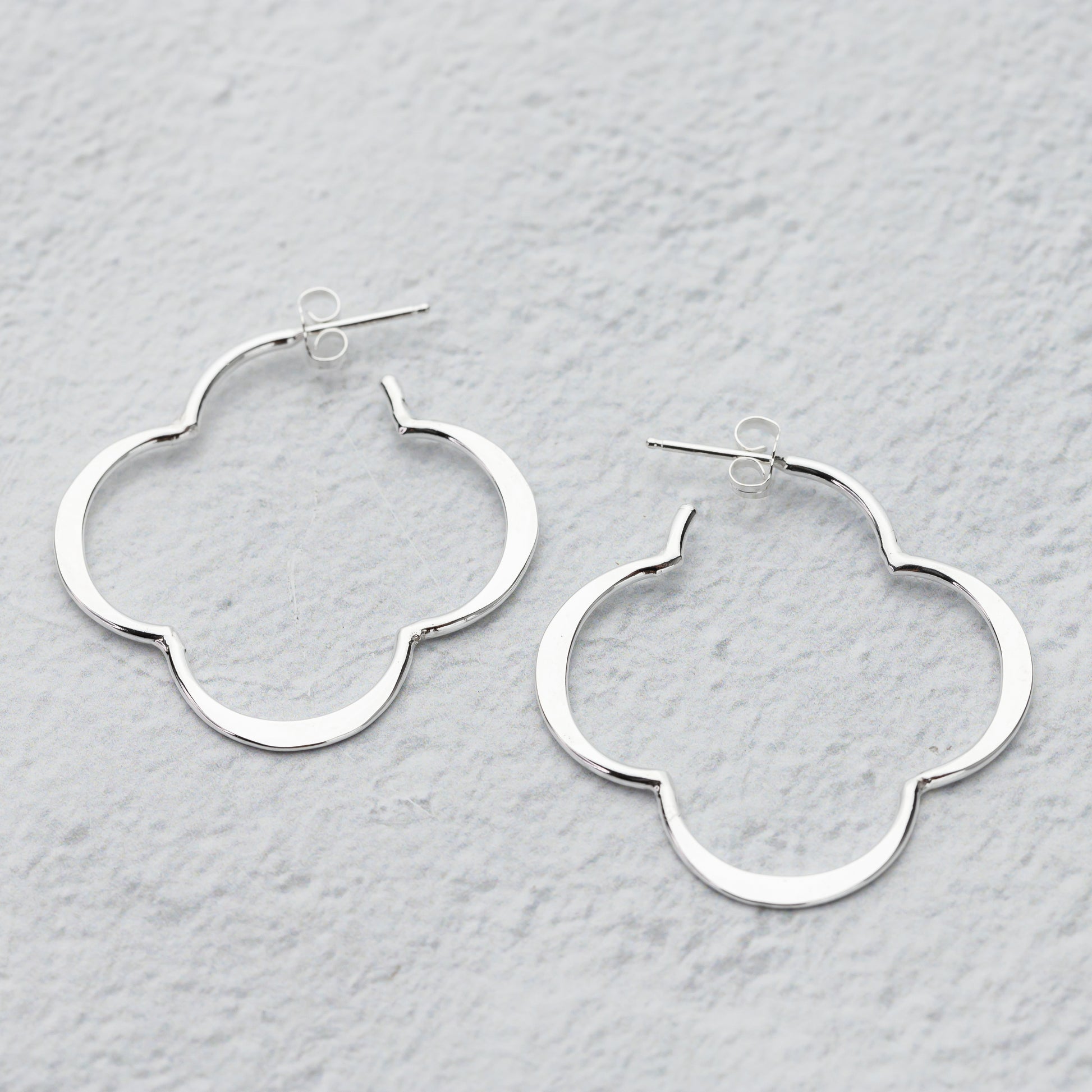 sterling Silver quatrefoil hoop earrings on a light gray background