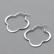 handmade sterling Silver quatrefoil hoop earrings on a gray background