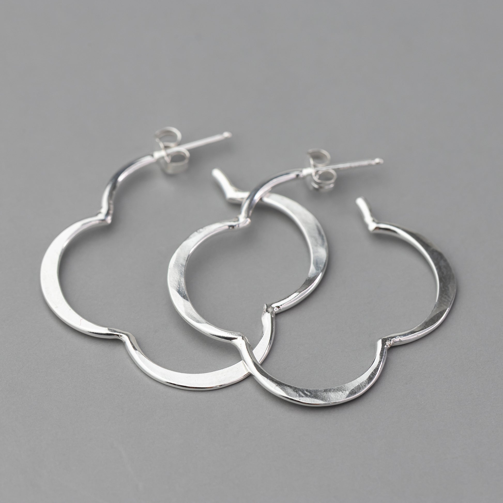 Pair of sterling silver post hoop earrings on a gray background