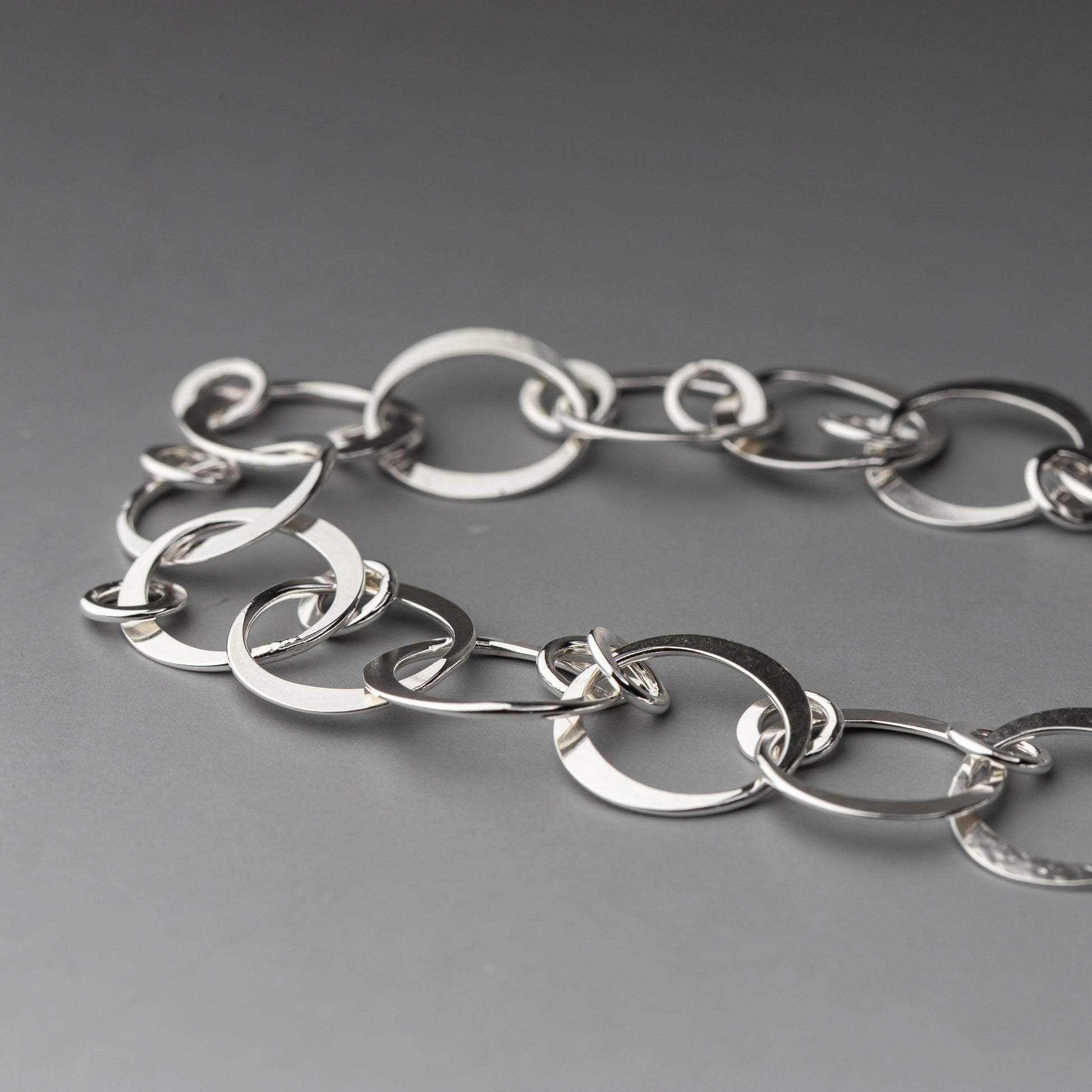 Silver chain bracelet on a gray background