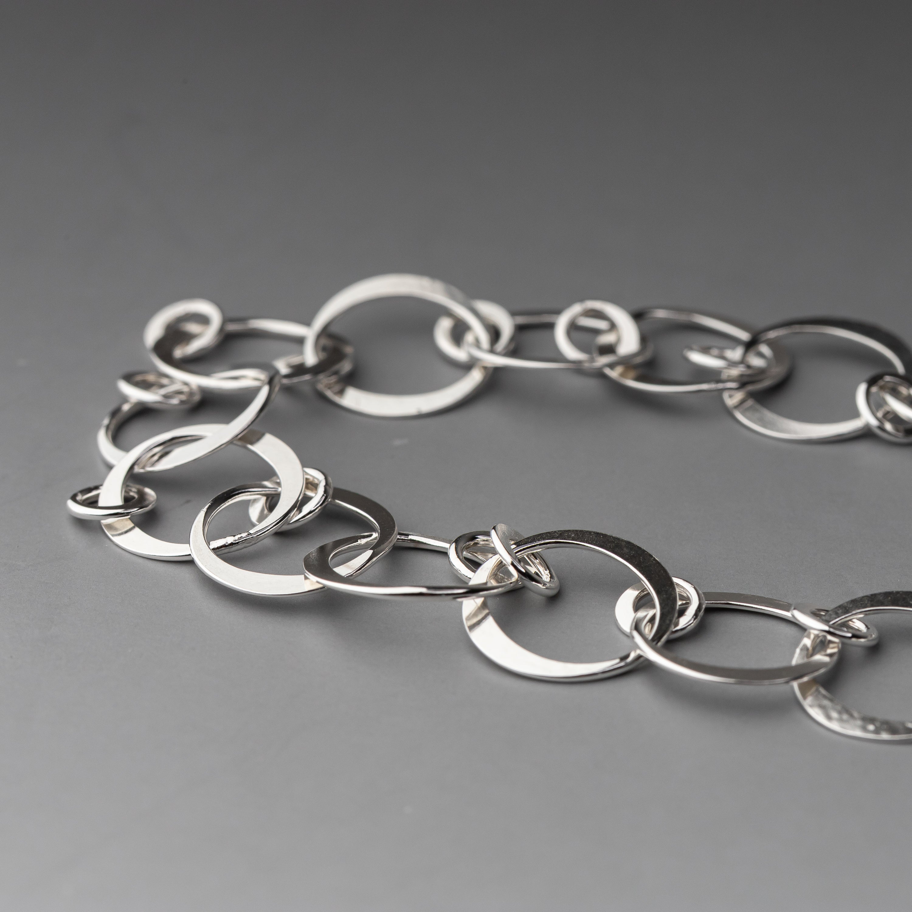 Silver chain bracelet on a gray background