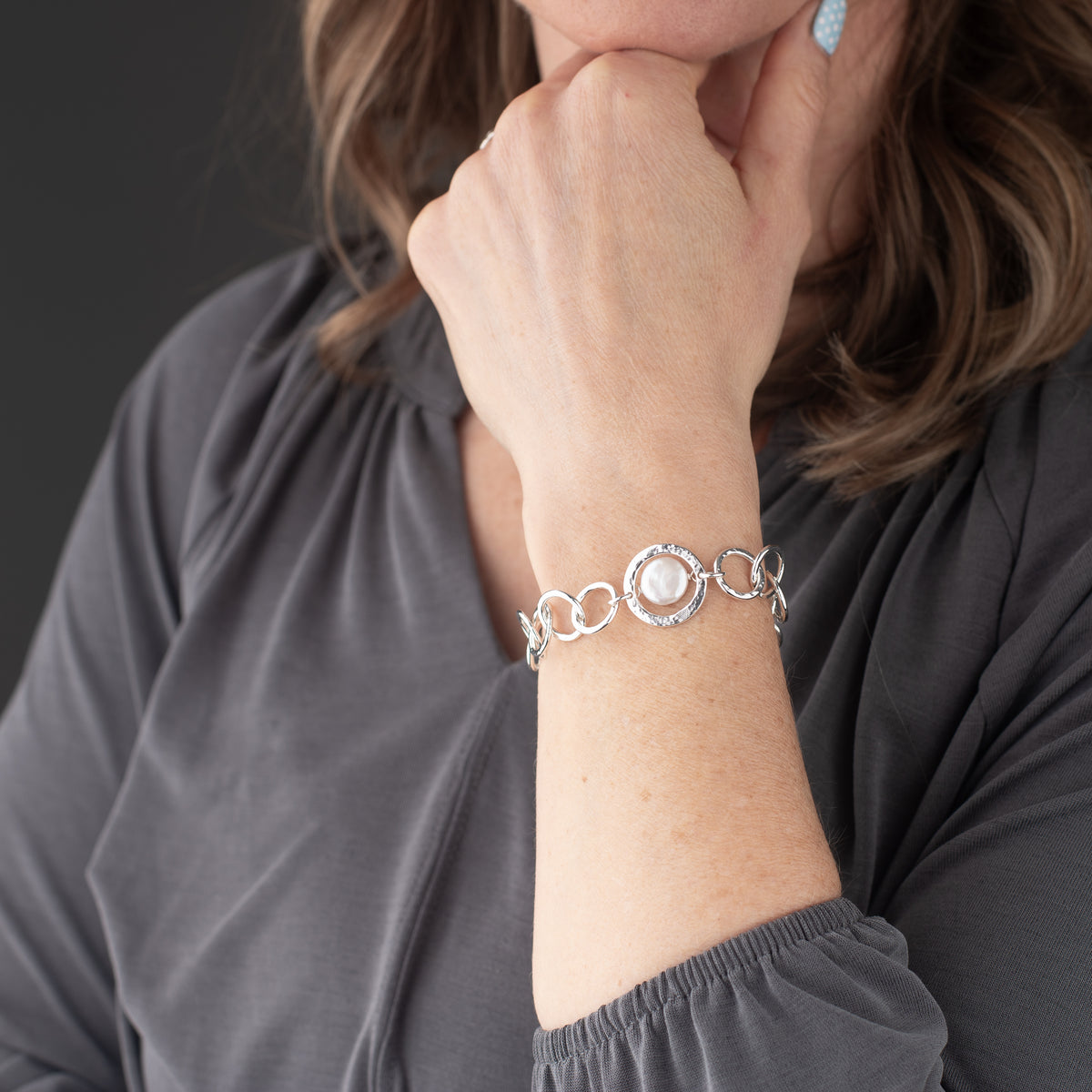 unique sterling silver and pearl bracelet shown being worn. This distinctive design is handmade and the hammered textured chain is adjustable with a toggle clasp