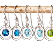 Custom handmade birthstone earrings with sparkling cz gemstones shown hanging from a branch.