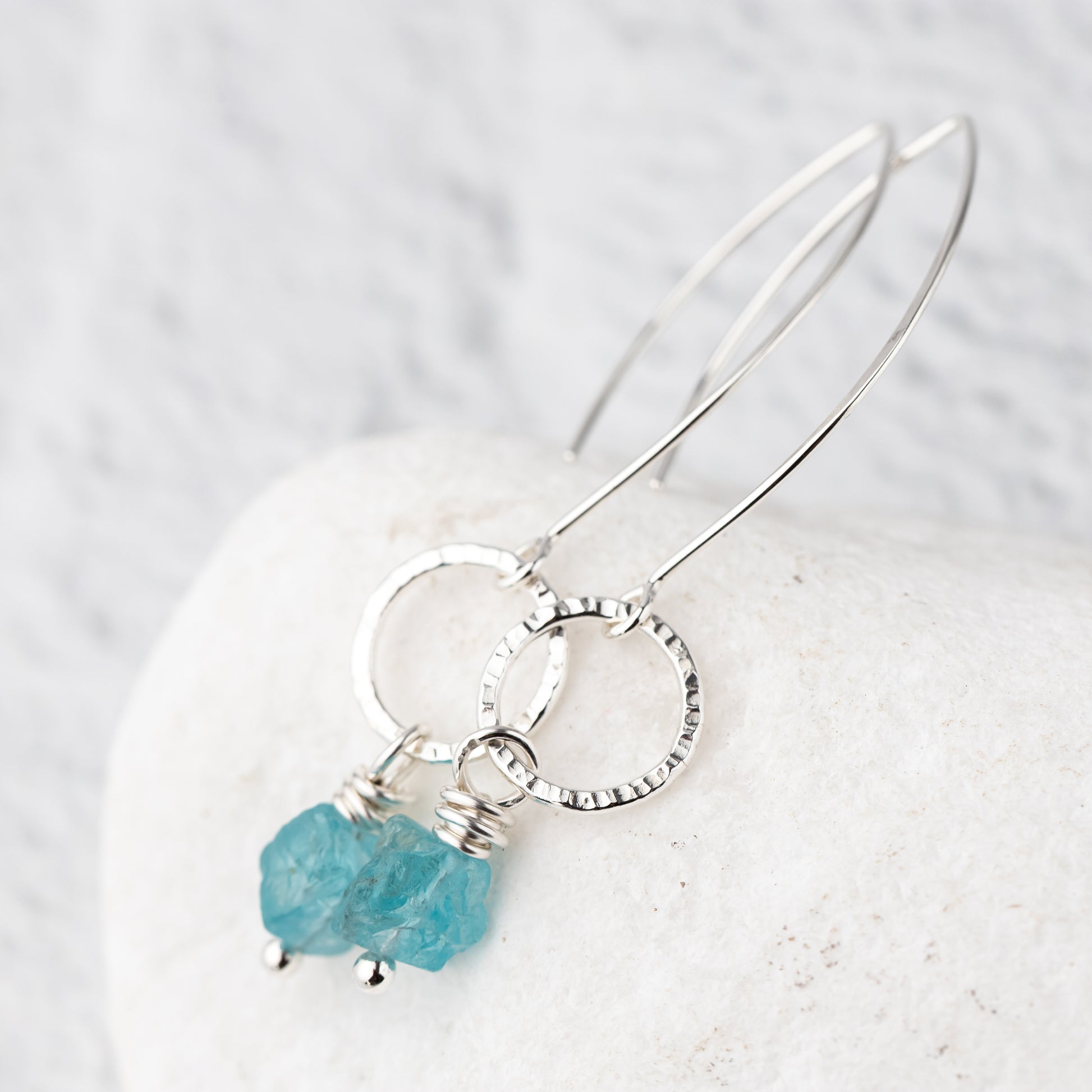 handmade Silver earrings with a turquoise apatite gemstone on a light background