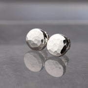 hammered sterling silver stud earrings in a round shape with a faceted texture and high shine.
