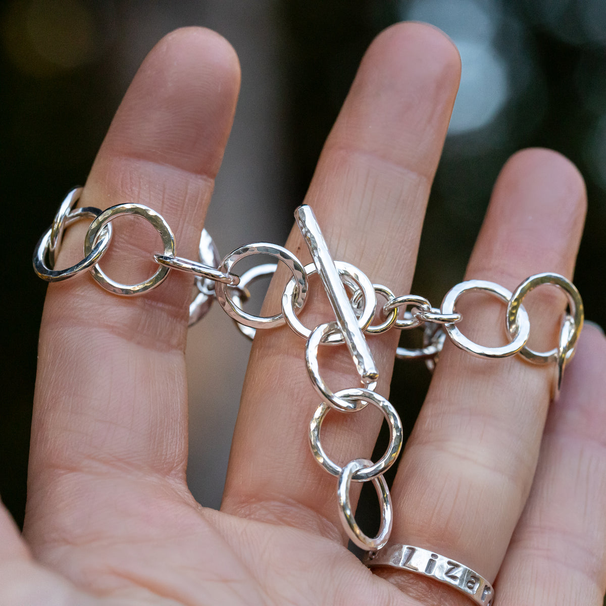 close up on the adjustable toggle on this handmade sterling silver chain bracelet.  The toggle bar fits securely into any of the links of the bracelet for a perfect fit.  Handmade and polished to a high shine