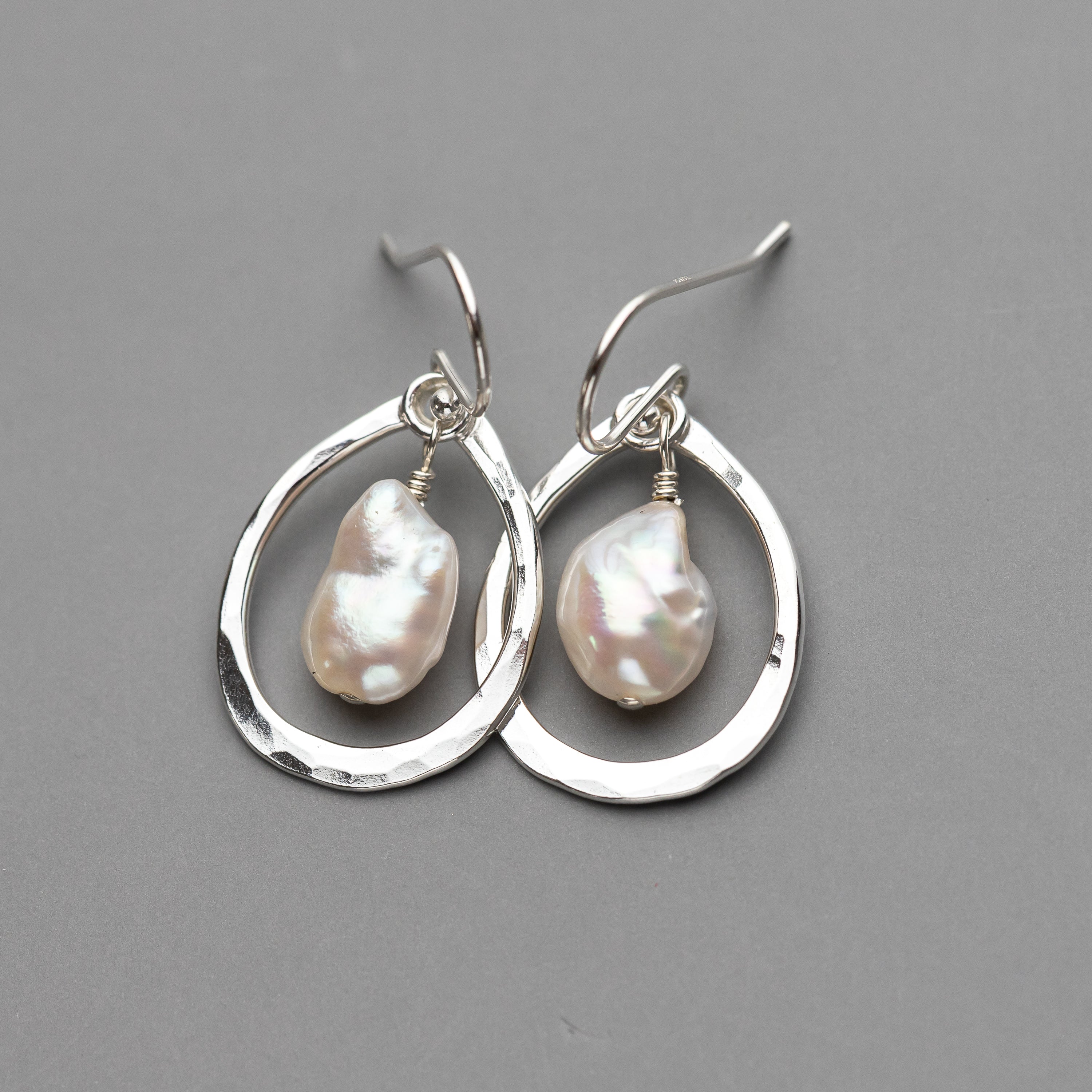 sterling Silver dangle earrings with baroque pearl drops on a gray background