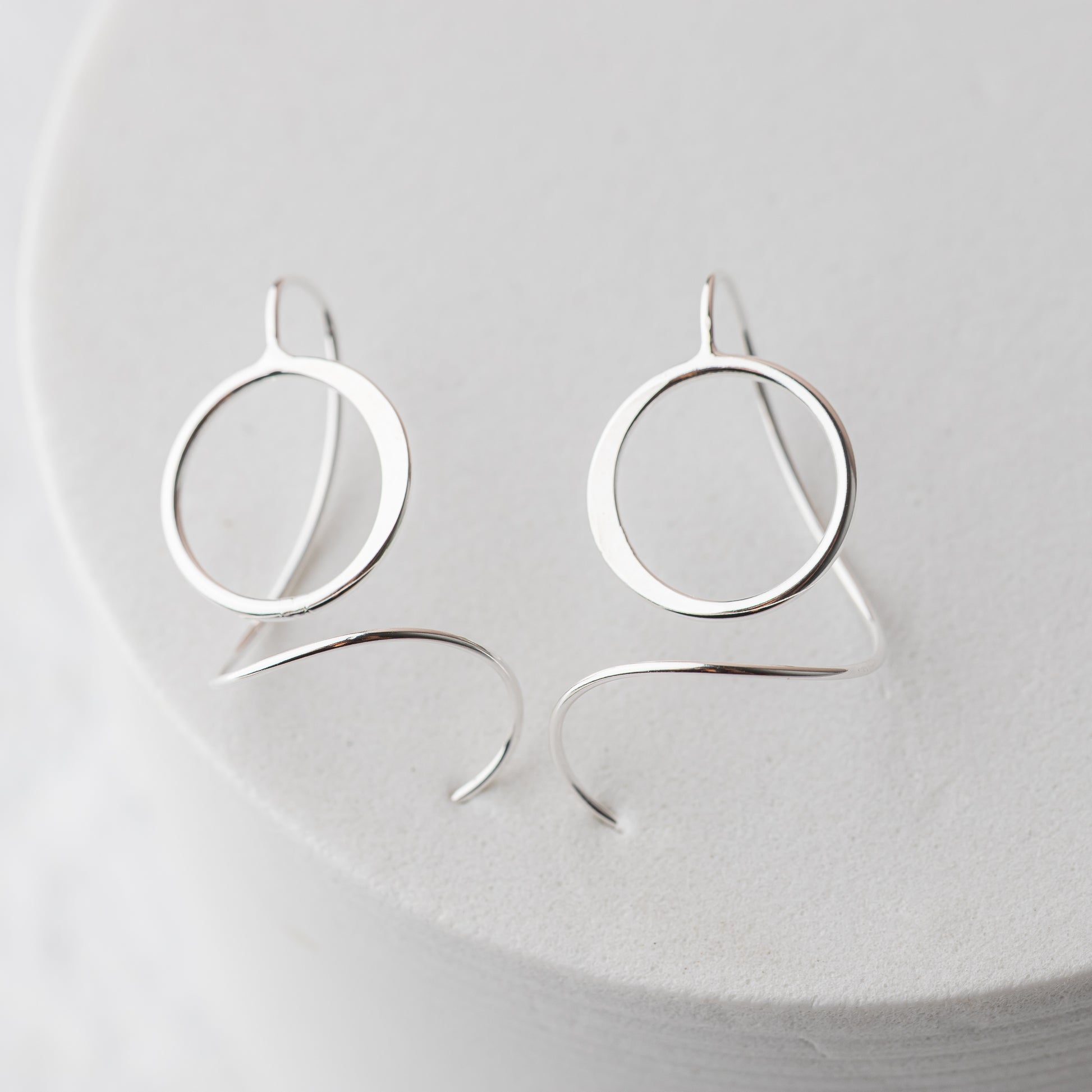 Silver hoop threader earrings on a white background