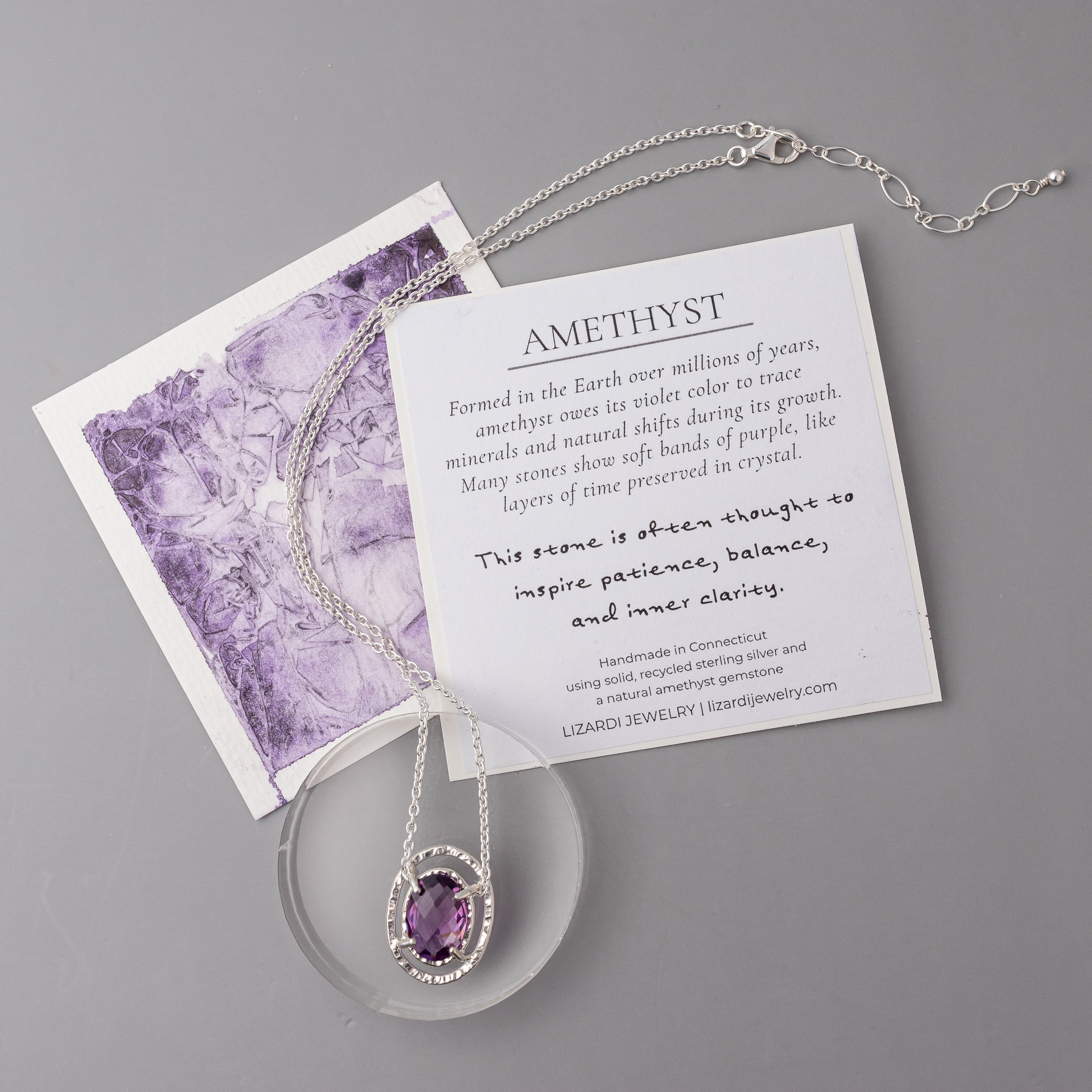 Amethyst necklace on a card with information about amethyst on a gray background