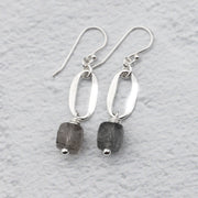 handmade sterling silver earrings with hammered silver ovals and tourmalinated quartz gemstones against a white background.