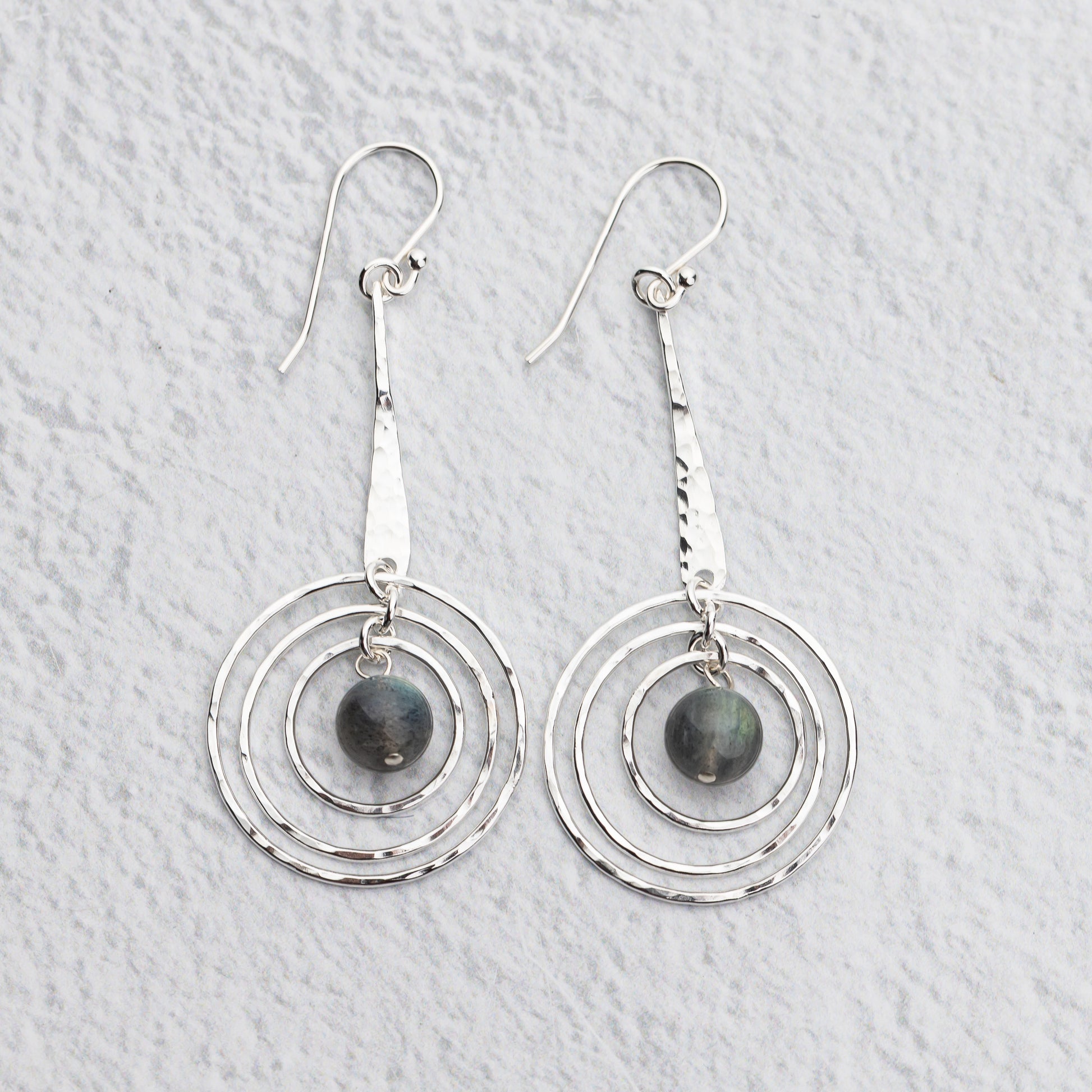 Handmade Sterling silver earrings with circular designs on a light gray background