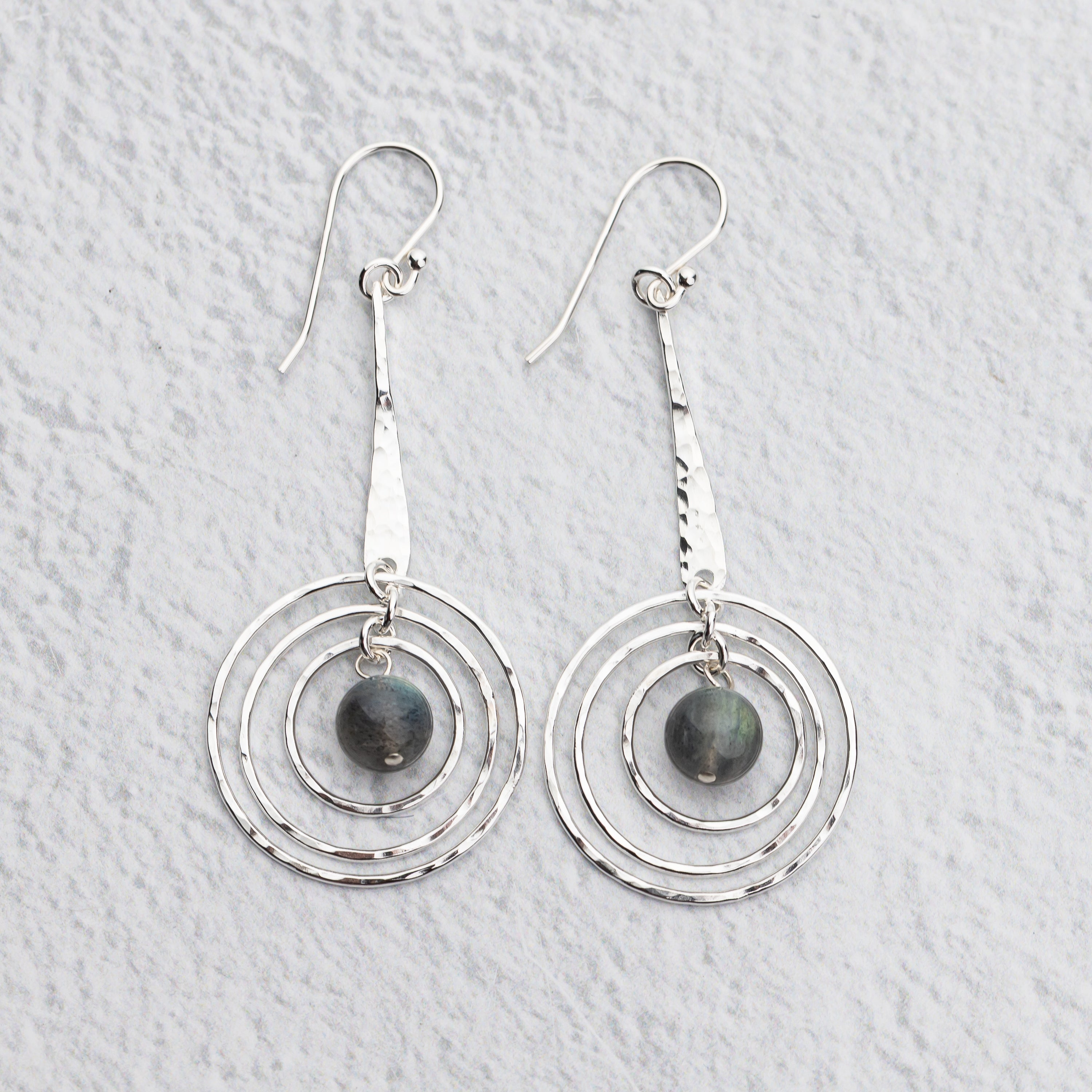 Handmade Sterling silver earrings with circular designs on a light gray background