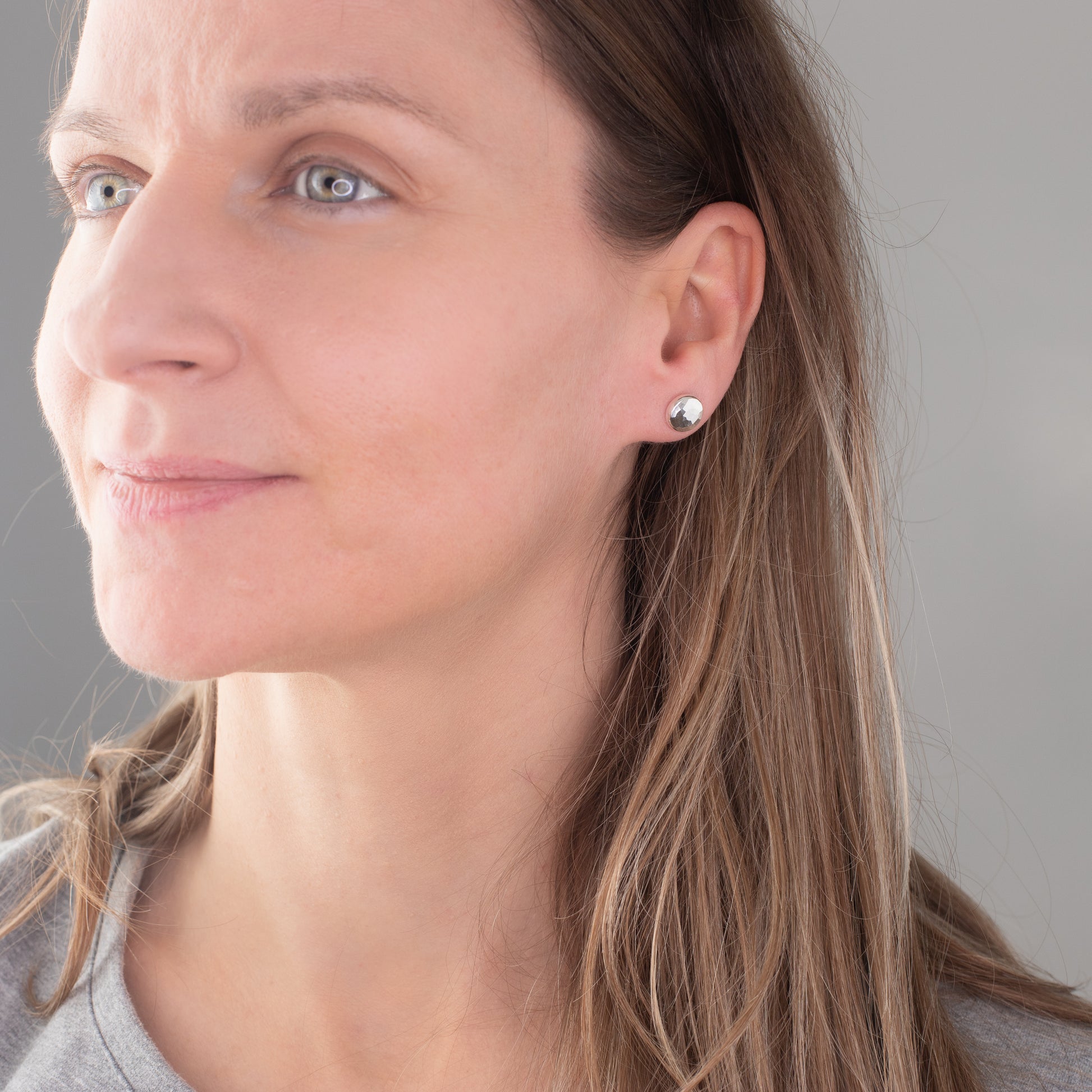 Handmade artisan silver stud earrings being worn on a model