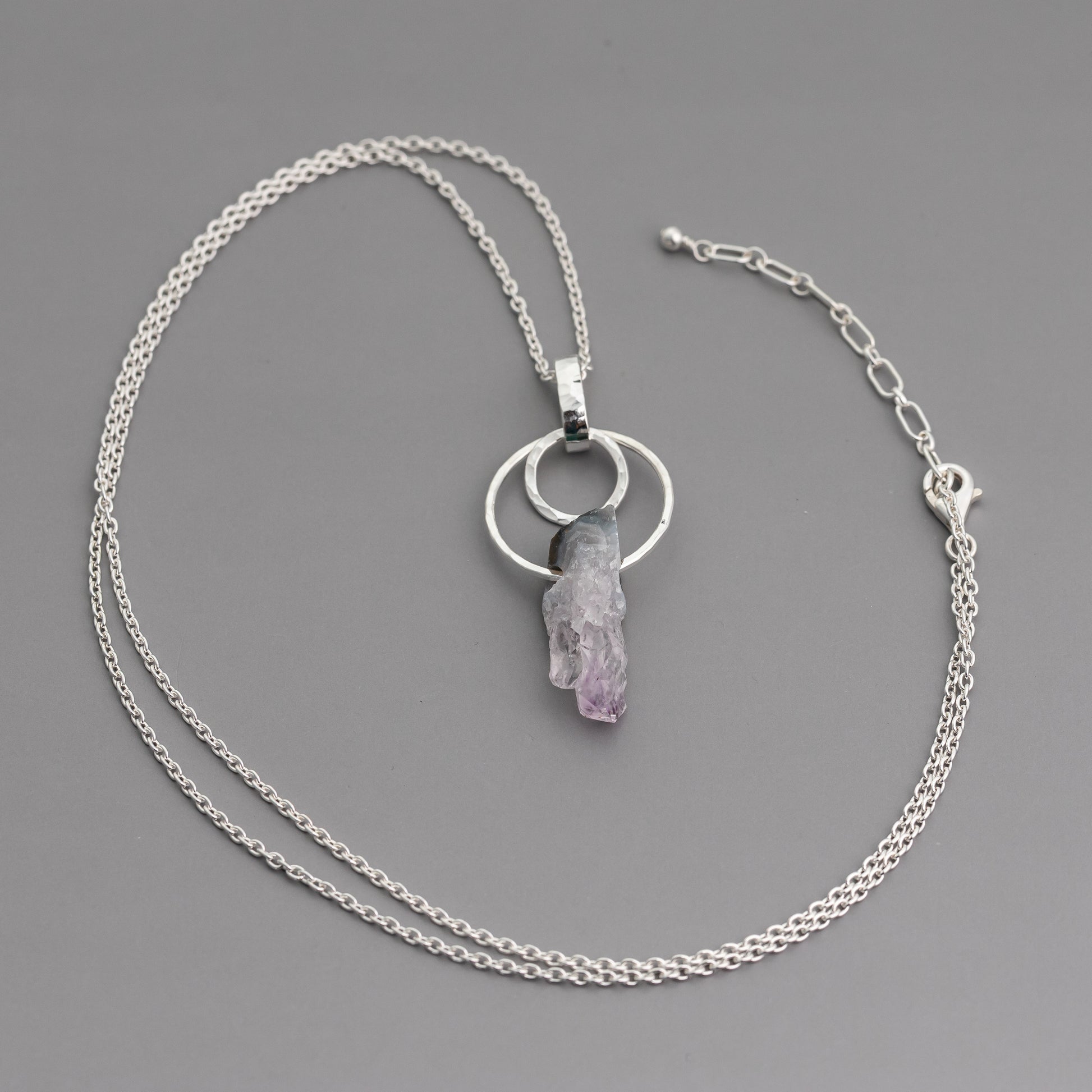handmade raw crystal necklace with sterling silver circles and an amethyst stalactite slice