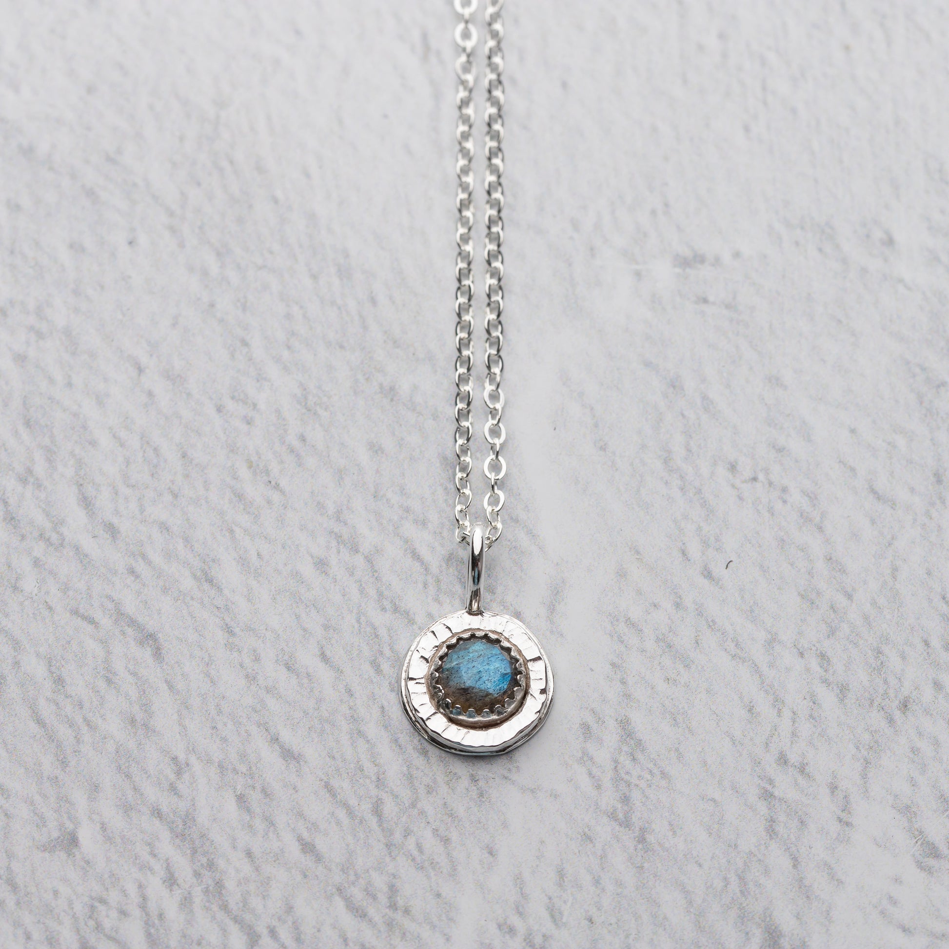 handmade small labradorite pendant necklace shown on a white background
