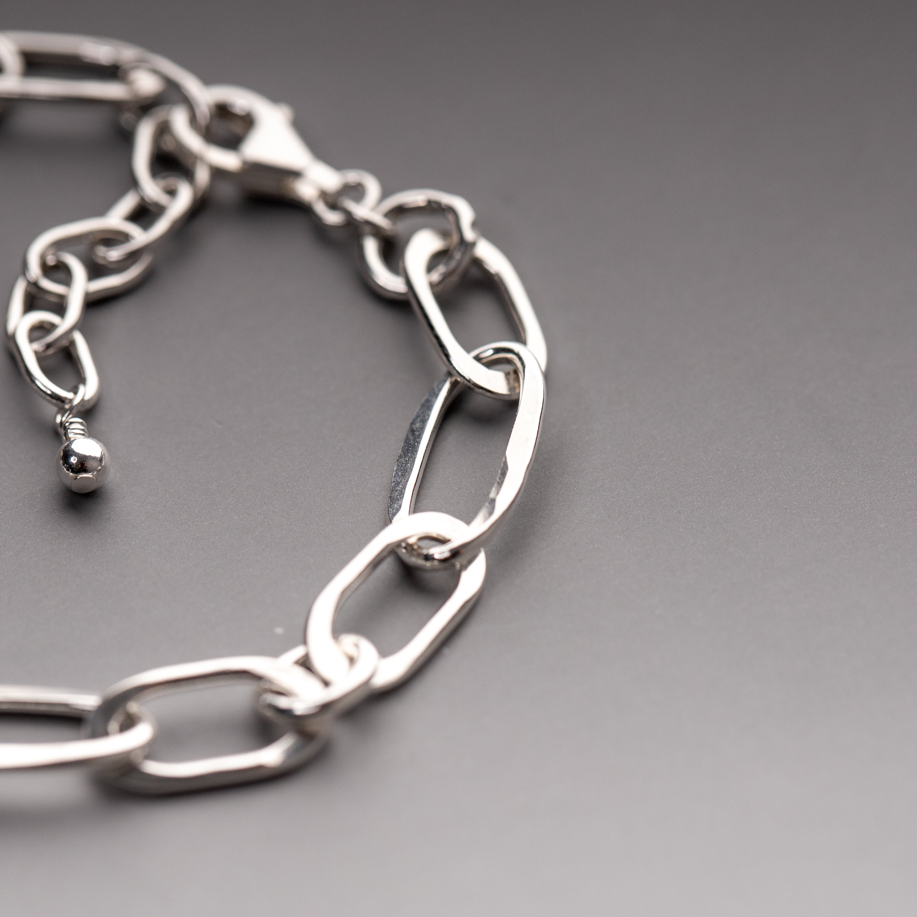 Adjustable chain bracelet with textured oval and round links